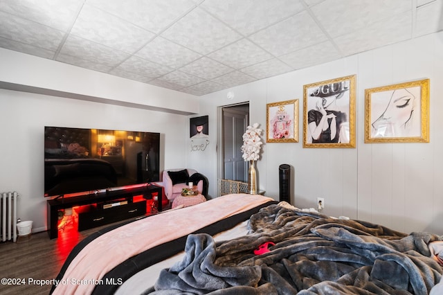 bedroom with wood-type flooring and radiator heating unit