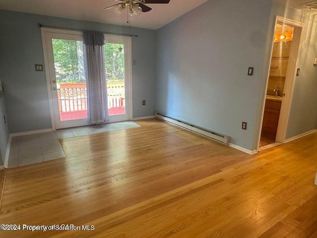 empty room featuring light hardwood / wood-style flooring, baseboard heating, and ceiling fan