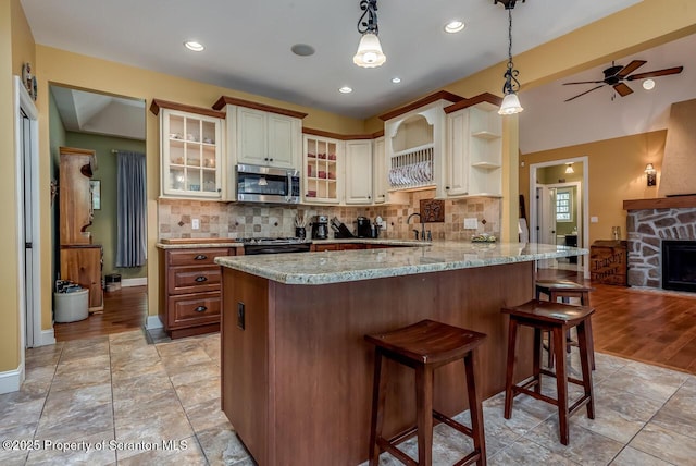 268 Winship Rd, Covington Twp, PA 18444 - kitchen with appliances with stainless steel finishes, decorative backsplash, a peninsula, a kitchen breakfast bar, and recessed lighting