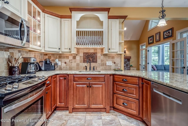 268 Winship Rd, Covington Twp, PA 18444 - kitchen with stainless steel appliances, tasteful backsplash, light stone counters, vaulted ceiling, and glass insert cabinets