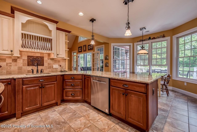 268 Winship Rd, Covington Twp, PA 18444 - kitchen with stainless steel dishwasher, a peninsula, tasteful backsplash, brown cabinetry, and hanging light fixtures