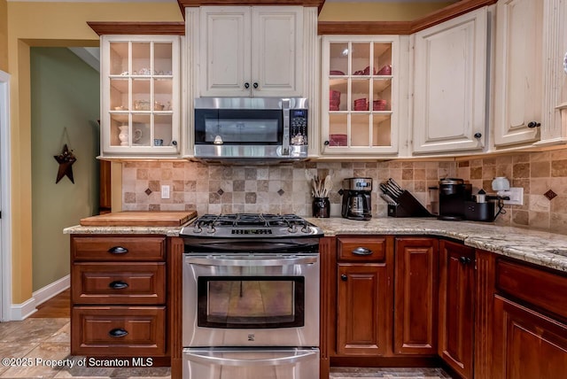 268 Winship Rd, Covington Twp, PA 18444 - kitchen featuring stainless steel appliances, decorative backsplash, glass insert cabinets, and white cabinetry