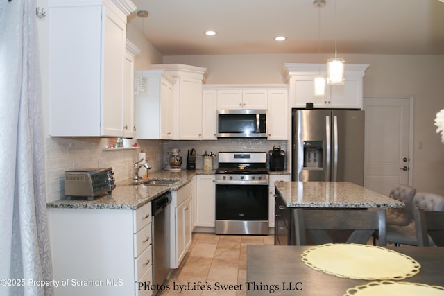 kitchen with a sink, tasteful backsplash, white cabinets, and stainless steel appliances