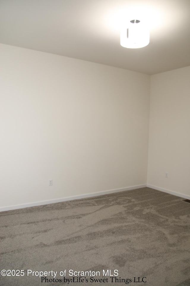 unfurnished room with carpet floors and baseboards