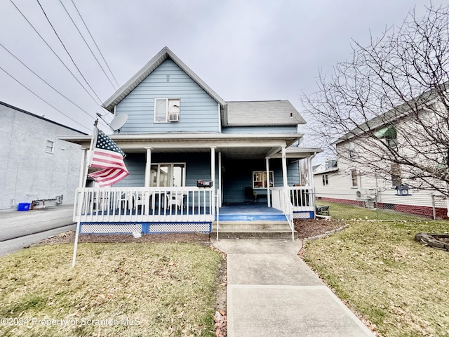 bungalow-style home with covered porch and a front lawn