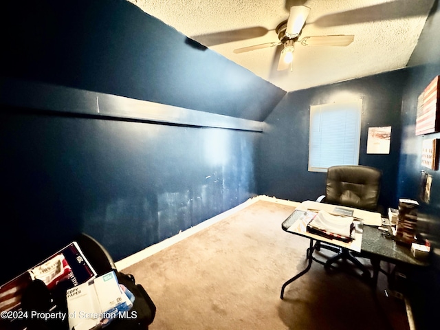 office featuring carpet flooring, ceiling fan, lofted ceiling, and a textured ceiling