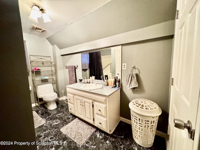 bathroom with vanity, toilet, and lofted ceiling