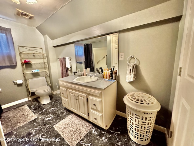 bathroom featuring vanity, vaulted ceiling, and toilet