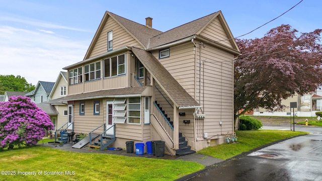 213-215 Bellman St, Throop, PA 18512 - rear view of property featuring entry steps, a shingled roof, a yard, board and batten siding, and a chimney