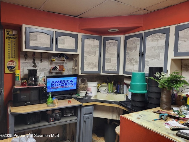 interior space featuring a paneled ceiling and black microwave