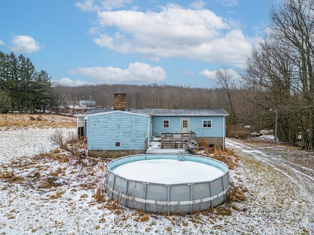 snow covered house with a pool side deck