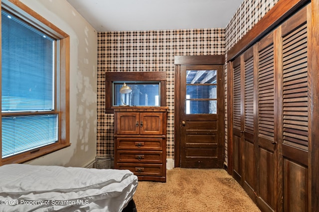 bedroom with light colored carpet and a closet