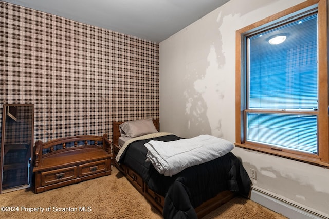 carpeted bedroom featuring a baseboard heating unit