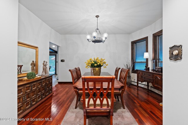 dining room with hardwood / wood-style floors, a chandelier, and a baseboard heating unit