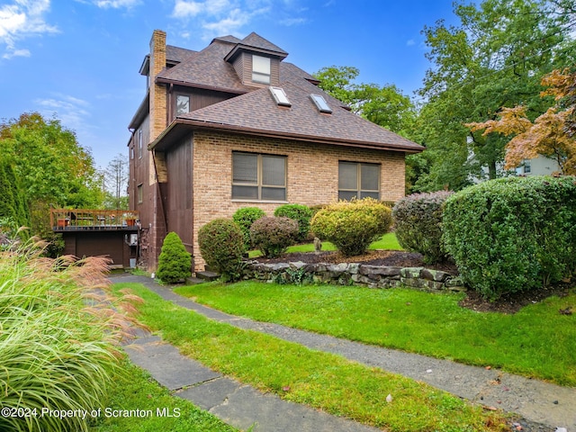 view of side of home with a yard