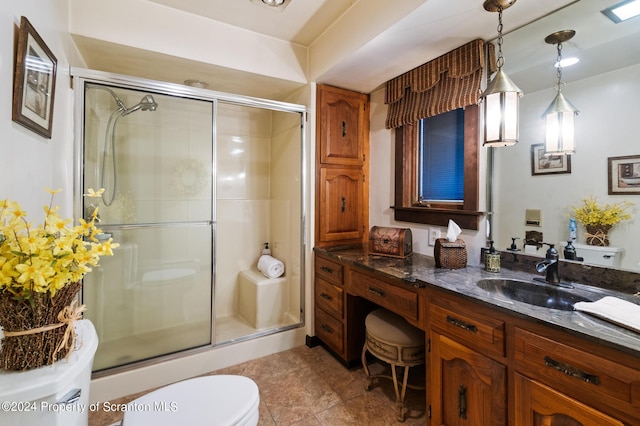 bathroom with vanity, toilet, and a shower with shower door