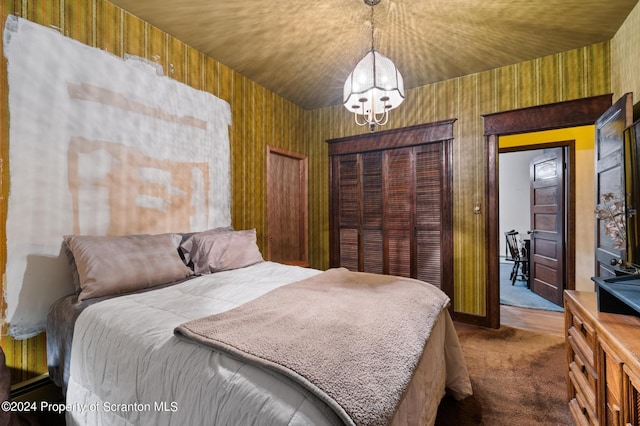 carpeted bedroom with an inviting chandelier and wood walls