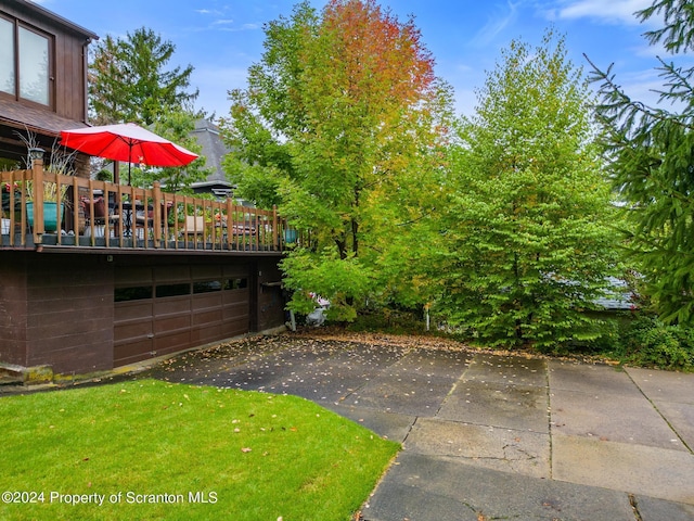 view of yard with a garage and a wooden deck