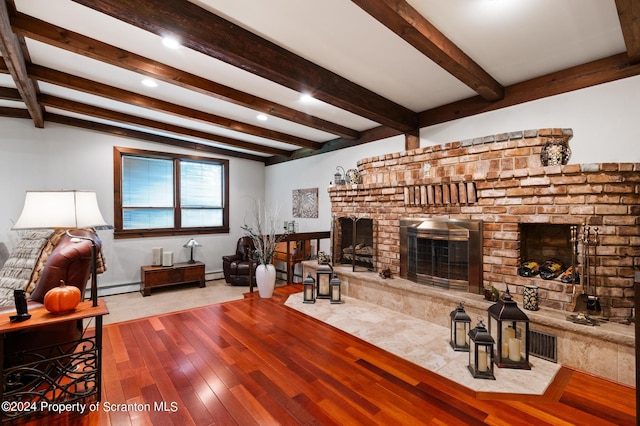 living room with a fireplace, a baseboard heating unit, light wood-type flooring, and beamed ceiling