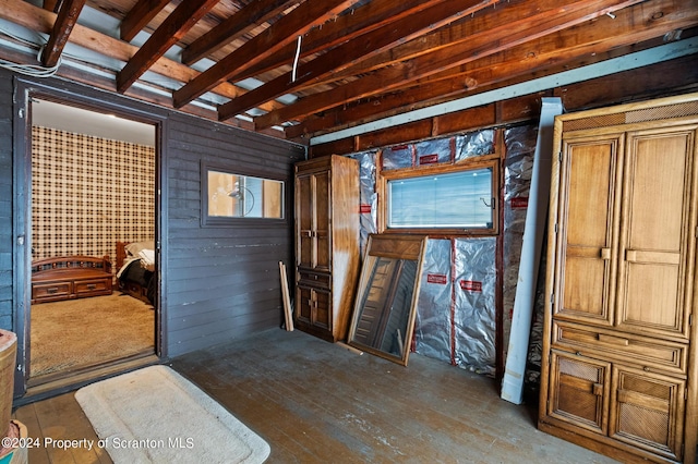 misc room featuring wood walls, hardwood / wood-style floors, and beamed ceiling