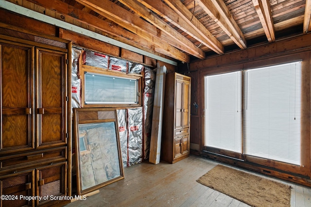 misc room with beam ceiling, wooden ceiling, wooden walls, and light hardwood / wood-style flooring