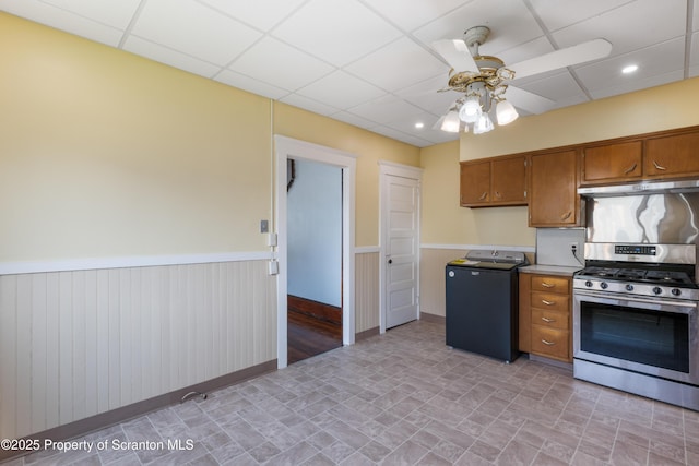 81 Rees St, Wilkes-Barre, PA 18702 - kitchen with stainless steel gas range oven, washer / dryer, under cabinet range hood, ceiling fan, and a wainscoted wall