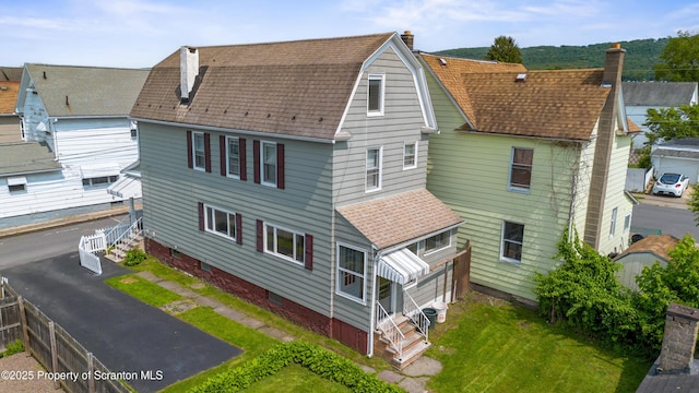 81 Rees St, Wilkes-Barre, PA 18702 - rear view of house featuring a shingled roof and a chimney