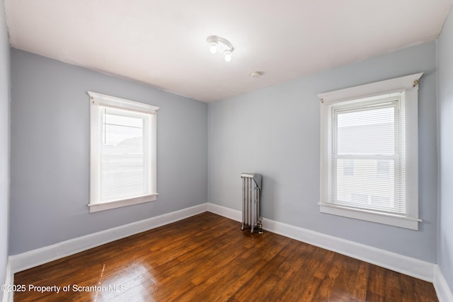 81 Rees St, Wilkes-Barre, PA 18702 - unfurnished room featuring dark wood-style floors, baseboards, plenty of natural light, and a smoke detector