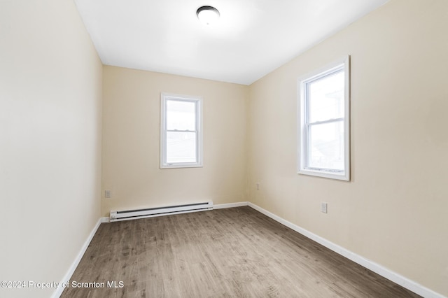 unfurnished room with light hardwood / wood-style floors and baseboard heating