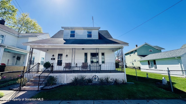 bungalow-style house with covered porch, fence, and a front yard