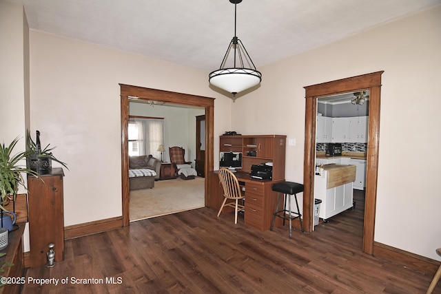 dining space with baseboards and dark wood-type flooring
