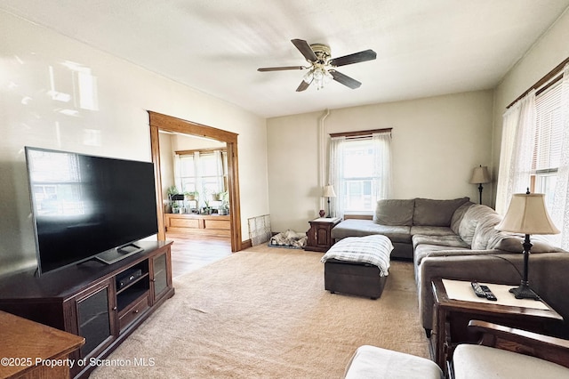 carpeted living area with a ceiling fan and a healthy amount of sunlight