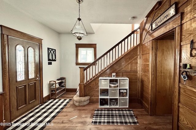 entrance foyer featuring baseboards, stairs, and wood finished floors