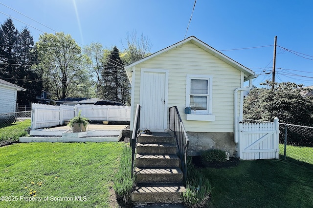 exterior space with a gate, a fenced backyard, and a front lawn