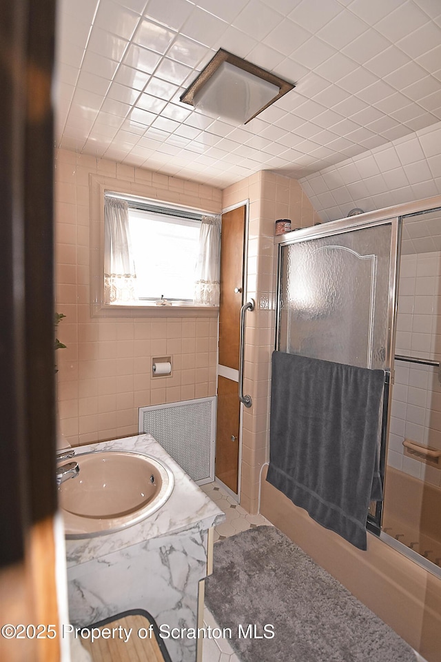 bathroom with vanity and enclosed tub / shower combo