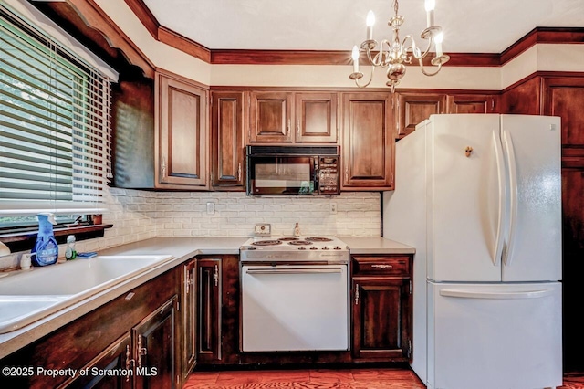 kitchen featuring pendant lighting, decorative backsplash, an inviting chandelier, white appliances, and ornamental molding