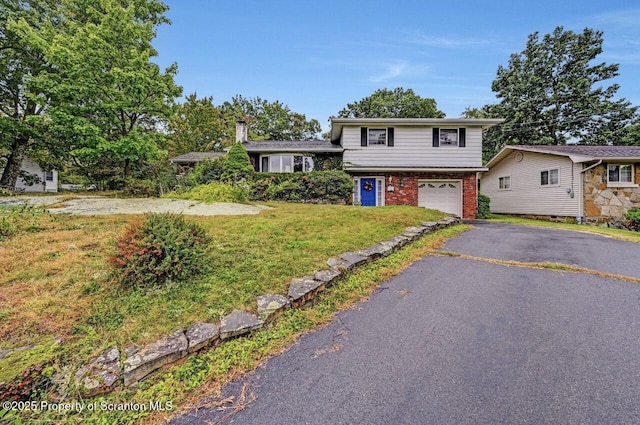 split level home with a front yard and a garage