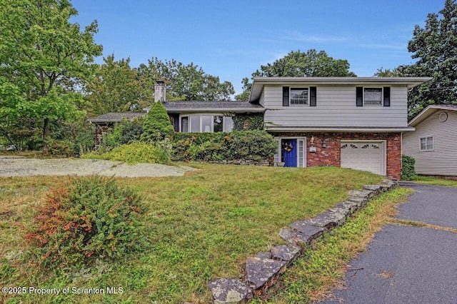 tri-level home featuring a garage and a front lawn