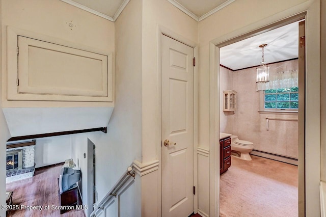 bathroom with toilet, vanity, a baseboard heating unit, and ornamental molding