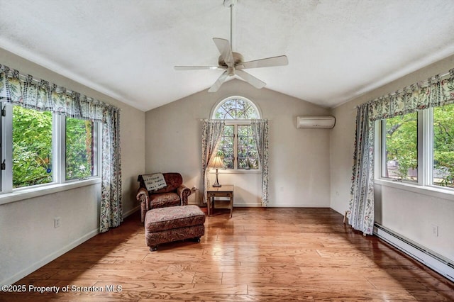 living area featuring a baseboard heating unit, ceiling fan, a wall mounted air conditioner, lofted ceiling, and light hardwood / wood-style flooring