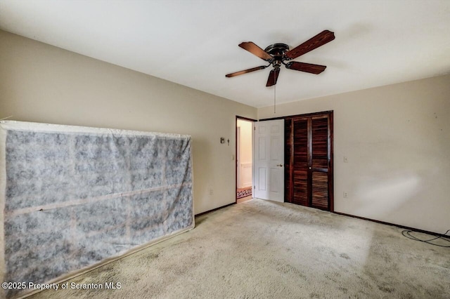 unfurnished bedroom featuring ceiling fan, a closet, and light carpet