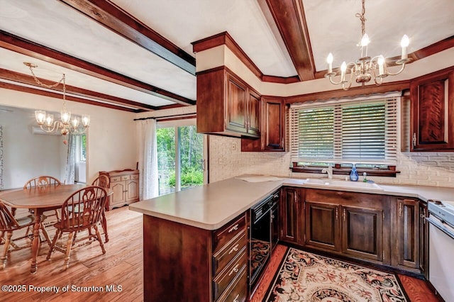 kitchen featuring beam ceiling, kitchen peninsula, a chandelier, and light hardwood / wood-style floors