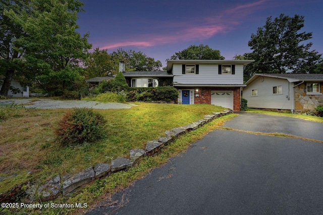 view of front of property featuring a garage and a lawn