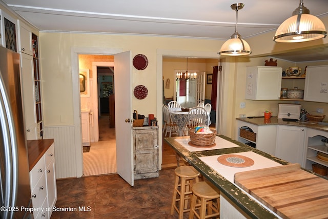 519 Sutton Rd, New Milford, PA 18834 - kitchen featuring open shelves, a chandelier, stainless steel refrigerator, white cabinets, and a wainscoted wall