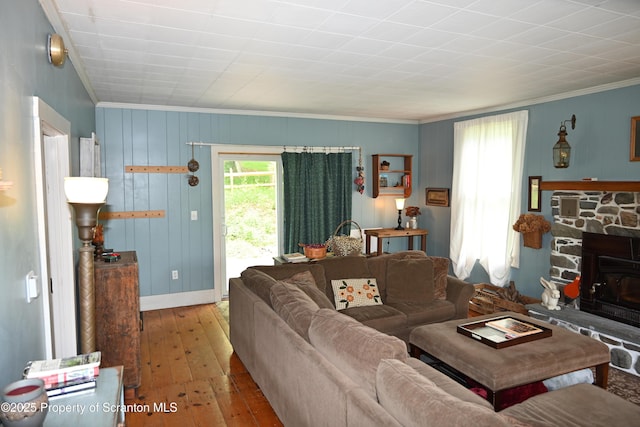 519 Sutton Rd, New Milford, PA 18834 - living area with ornamental molding, hardwood / wood-style floors, a wood stove, baseboards, and wooden walls
