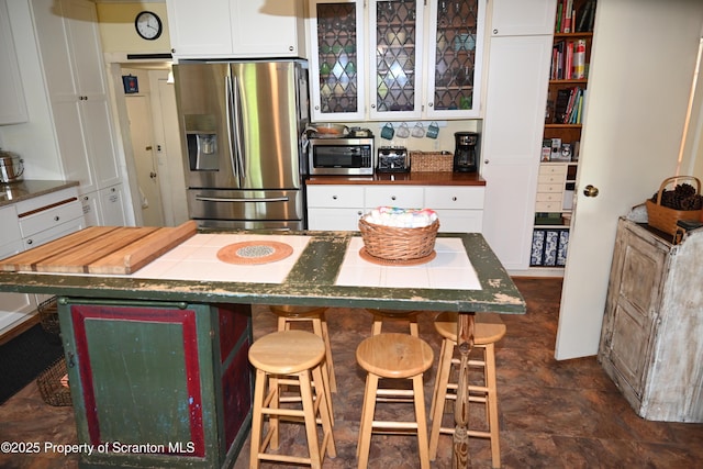 519 Sutton Rd, New Milford, PA 18834 - kitchen featuring stainless steel appliances, white cabinets, a breakfast bar area, and glass insert cabinets