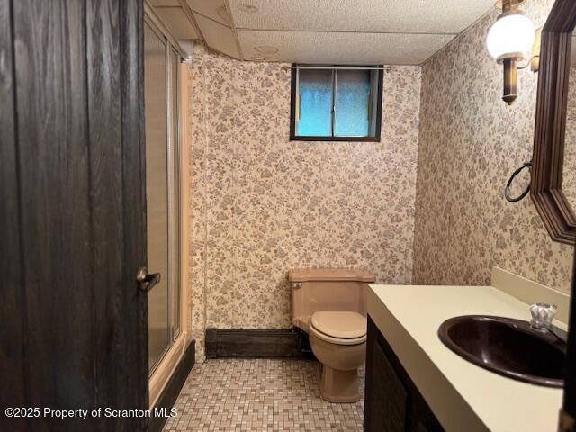 bathroom featuring wallpapered walls, toilet, a shower stall, tile patterned floors, and vanity
