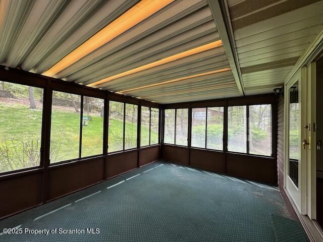 unfurnished sunroom with carpet flooring