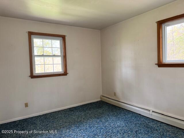 unfurnished room featuring dark colored carpet, baseboards, and baseboard heating