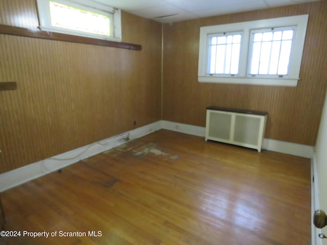 spare room featuring dark hardwood / wood-style floors and radiator